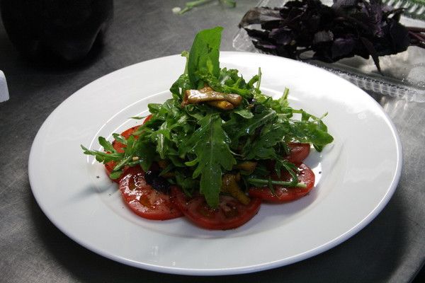 Salad with chanterelle mushrooms on a bed of tomato