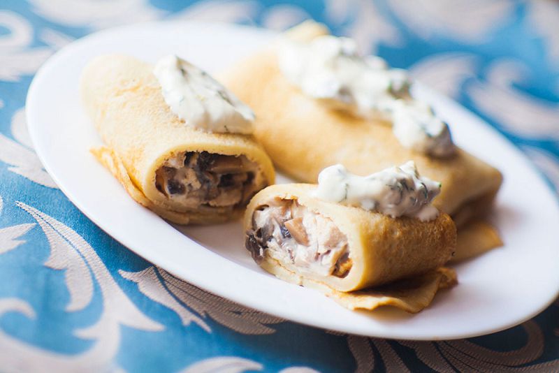 Pancakes stuffed with chicken, mushrooms and cheese sauce