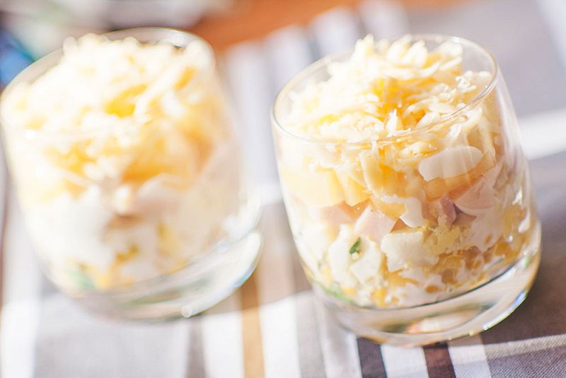 Layered salad with ham, corn, cheese and pineapple