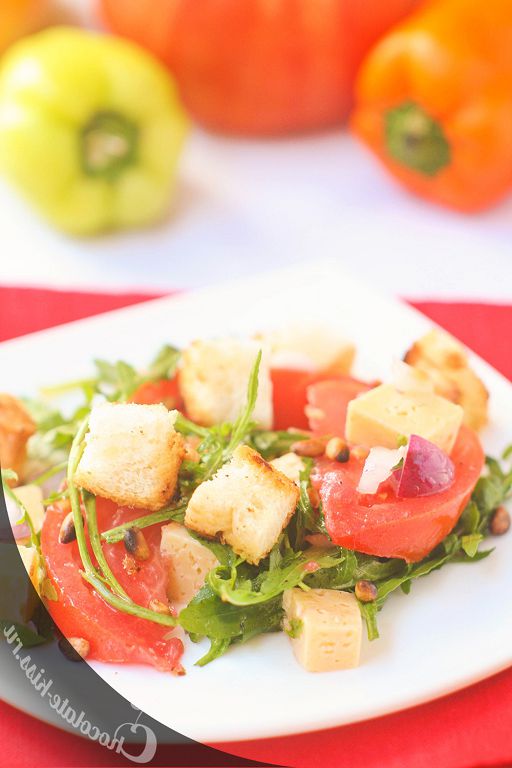 Arugula salad, tomatoes and feta cheese with pine nuts