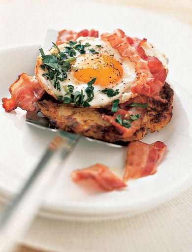 Fried eggs with bacon on potato and apple cakes
