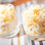 Layered salad with ham, corn, cheese and pineapple